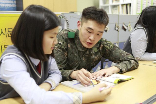 육군25사단이 경기도 파주시 삼광고등학교 학생들을 대상으로 진행하는 ‘군 학습 멘토링’에서 윤정현 상병이 학생의 개인 공부를 돕고 있다.  부대 제공