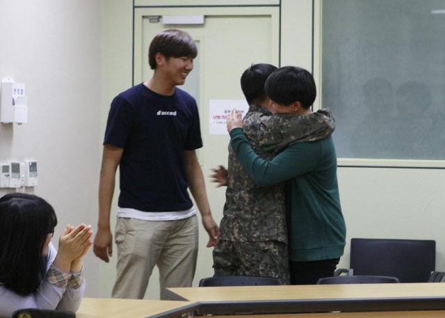 경기도 파주시 적성면사무소에서 열린 육군25사단 ‘군 학습 멘토링’에서 윤정현(가운데) 상병과 수료생인 박희재(오른쪽) 씨가 재회를 기뻐하며 포옹하고 있다.  부대 제공