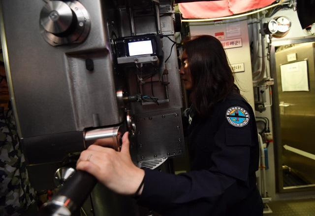 잠수함 승조원 체험을 하고 있는 본지 조아미 기자가 탐색 잠망경을 좌우로 움직이며 인근의 상선들을 확인하고 있다. 사진=조용학 기자