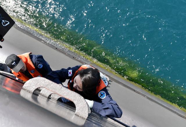 잠수함 갑판에서 함교탑으로 아슬아슬하게 올라가는 조아미 기자의 긴장된 모습.  사진=조용학 기자