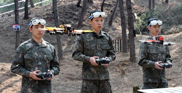 지난해 육군정보학교에서 열린 ‘제1회 산·학·연·군 드론 전투 콘퍼런스’에서 드론 전투대회 참가자들이 드론을 날리고 있다.  국방일보 DB