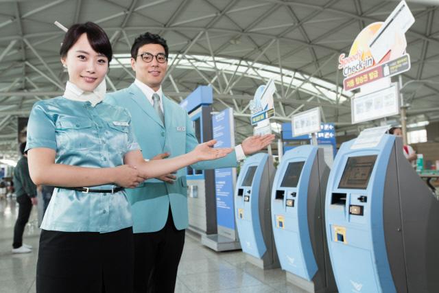 대한항공 직원들이 짧은 시간 안에 탑승 수속을 마칠 수 있는 공항 내 탑승권 자동발급기 키오스크 서비스를 소개하고 있다.  연합뉴스