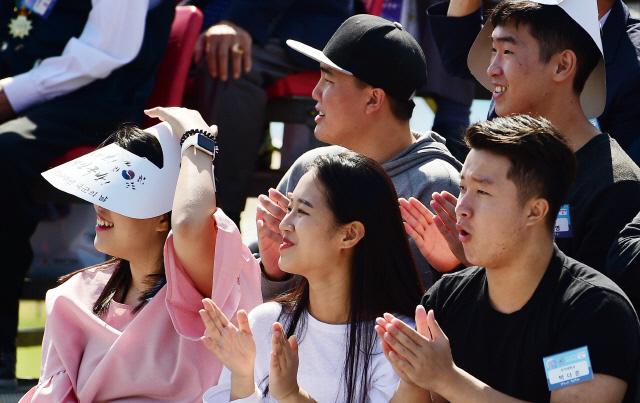 행사에 참가한 관람객들이 연합 고공강하를 보며 환하게 웃고 있다. 