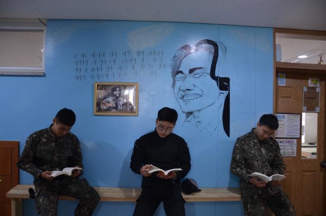 육군203특공여단 쌍호대대 장병들이 ‘뮤직공간’으로 꾸민 생활관 내 복도에 앉아 책을 읽고 있다.