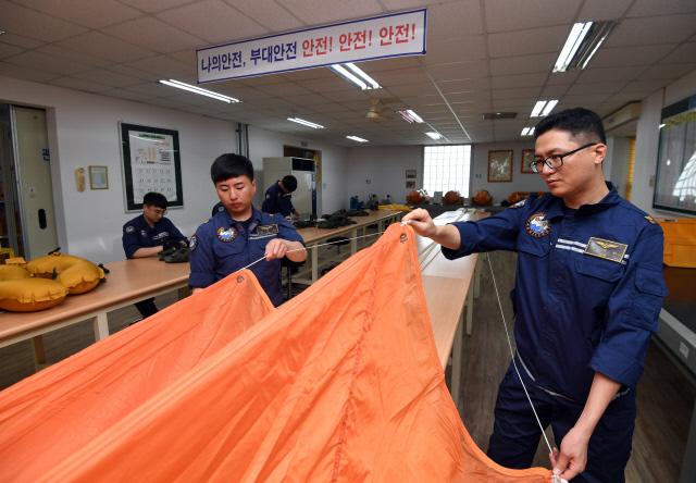 항공 장비 부사관들이 위급 상황에서 승무원의 생환을 도울 낙하산을 점검하고 있다. 사진=양동욱 기자