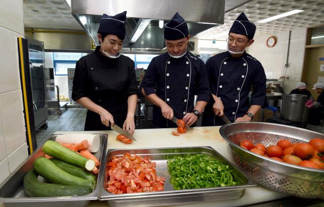 조리 부사관 윤지연(왼쪽) 중사가 해군진기사 근무지원전대 합동육상식당에서 조리병과 함께 점심을 준비하고 있다.