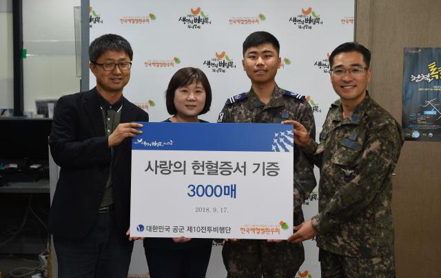 공군10전투비행단 이복기(맨 오른쪽) 주임원사와 대표병사 송영민(오른쪽 둘째) 병장이 17일 서울 영등포구 한국백혈병환우회에서 10전비 장병들의 헌혈증 3000장을 기부하며 환우회 관계자들과 기념촬영을 하고 있다.   양동욱 기자