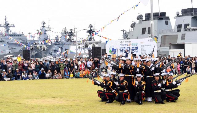 14일 제주민군복합항에서 2018 대한민국 해군 국제관함식의 일환으로 열린 해군 부대개방 행사에 참가한 시민들이 함정 앞에서 펼쳐진 해군 의장대 시범을 관람하고 있다.   해군 제공