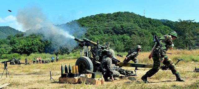 쌍용훈련 중 105mm 곡사포를 사격하고 있는 현역과 예비역 장병들.