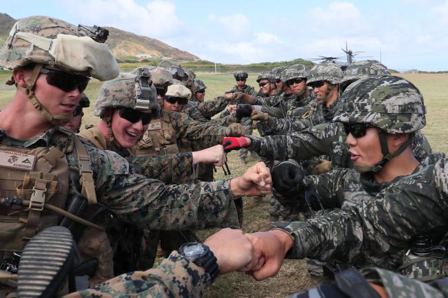 림팩훈련  미국 하와이에서 열린 세계 최대 규모의 연합훈련 ‘2018 환태평양훈련(RIMPAC)에 참가한 대한민국 해병대원들이 다국적군 헬기 탑승·이탈 훈련을 마치고 미국 해병대원들과 주먹을 맞부딪치며 우정을 확인하고 있다.  미국 호놀룰루=한재호 기자(2018.07.07.)