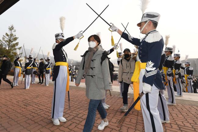 14일 기초군사훈련에 돌입한 공군사관학교 71기 예비 생도들이 지도생도들의 교차칼을 받으며 별관으로 이동하고 있다.  부대 제공