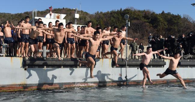 해군 해난구조대 대원들이 17일 경남 진해군항에서 열린 동계 혹한기 내한훈련 중 맨몸수영을 하기 위해 바다로 뛰어들고 있다. 양동욱 기자