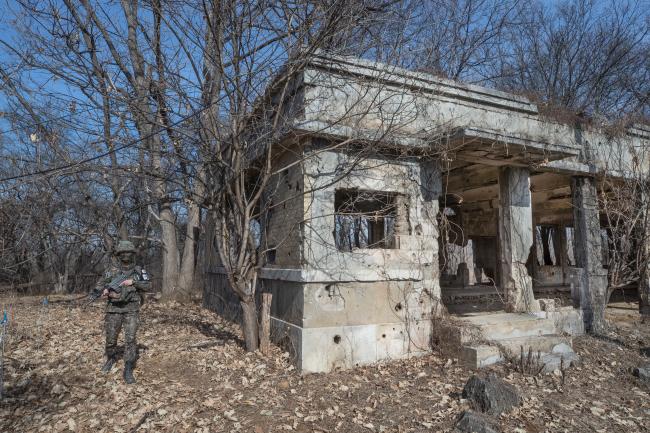 14일 경기도 파주시 서부전선 비무장지대(DMZ)에 남아있는 장단면사무소에서 한 육군 병사가 경계근무를 하고 있다. 1934년에 지어진 이 건물은 일제시대 때 장단 지역의 행정업무를 한 곳이며 현재 6·25전쟁 당시 총탄 흔적을 지닌 채 서 있다.   연합뉴스