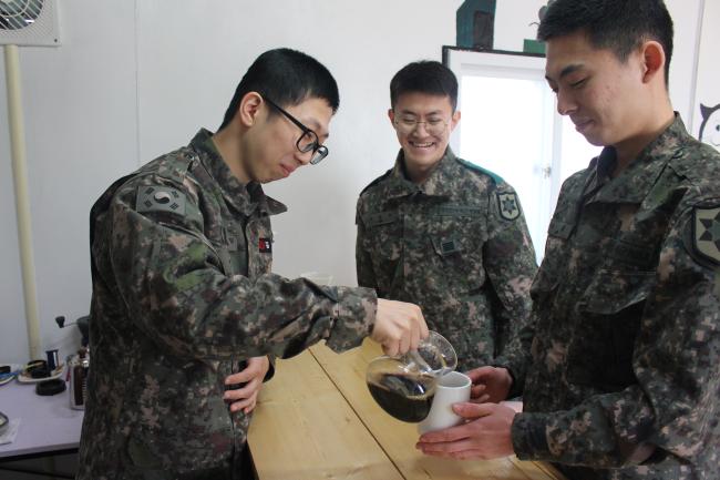 
육군12사단 최갑석대대 신민철(맨 왼쪽) 상병이 정성껏 내린 커피를 전우들에게 나눠주고 있다. 

 부대 제공