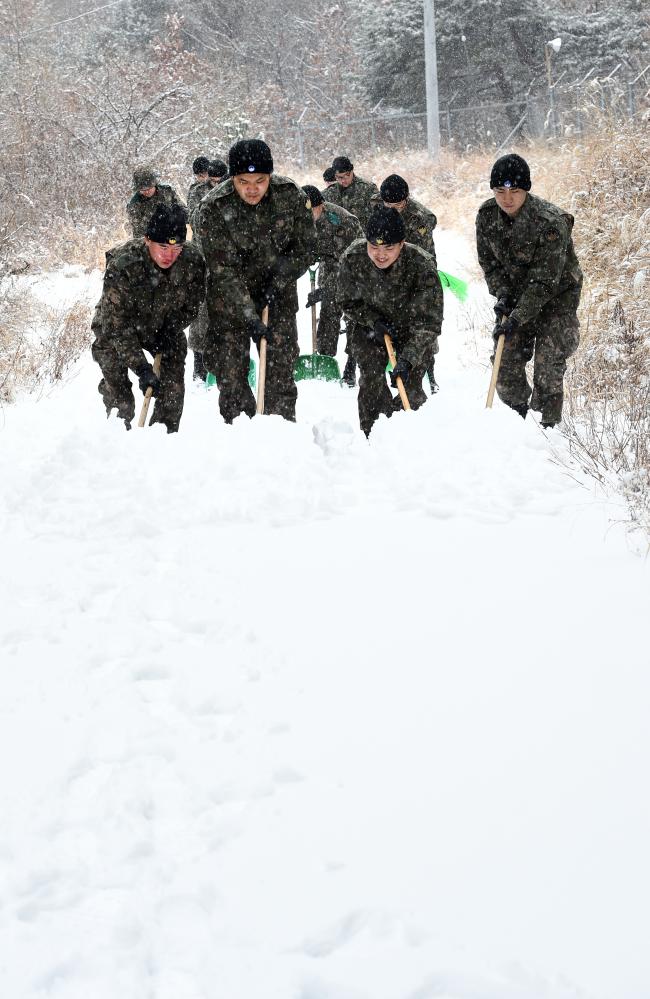 19일 오후 2시 기준 최대 7㎝의 많은 눈이 내린 강원도 양구의 육군21사단 무학대대 장병들이 대대적인 기동로 제설작전을 펼치고 있다. 이날 오전 서울·경기·강원 등 전국 많은 지역에 대설특보가 발효됐고, 특히 기온이 낮은 최전방 지역에는 오후까지도 굵은 눈발이 이어졌다. 사단은 올겨울 언제든 신속히 제설작전이 이뤄질 수 있도록 만반의 준비를 함으로써 최상의 경계태세 및 전투준비태세를 유지하고 있다.  양구=조용학 기자