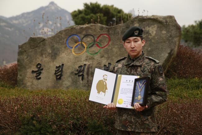 육군72사단 남승모 대위가 헌혈 100회를 달성해 대한적십자사로부터 받은 헌혈 유공장 명예장과 함께 기념사진을 찍고 있다.  부대 제공 