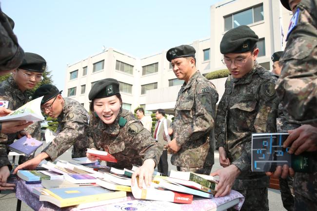 19일 육군2작전사령부가 개최한 ‘One Book, We Together!’ 행사에서 장병들이 민간 기업 대표들이 기증한 770권의 도서 가운데 자신이 읽고 싶은 책 한 권을 고르고 있다.  부대 제공  