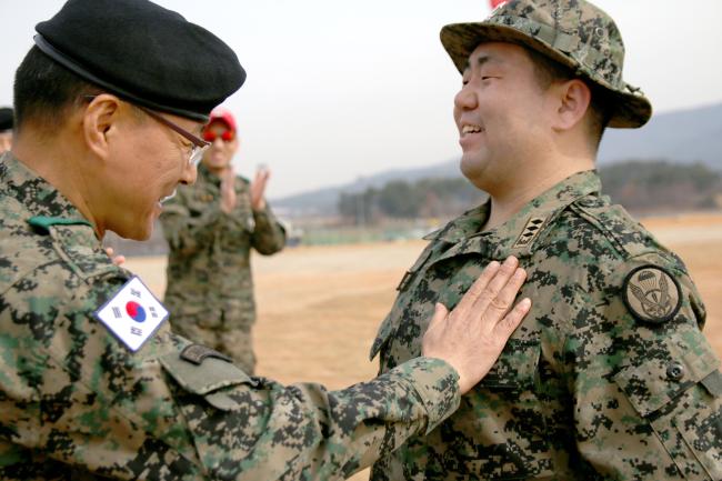 육군7공수특전여단 천마부대 군종목사 최용훈(오른쪽) 대위가 강하 20회를 달성한 뒤 부대장으로부터 낙하산 은성 휘장을 받고 있다.  부대 제공