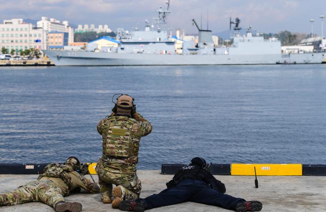21일 동해 군항에서 실시한 해군1함대의 합동 해상 대테러훈련에서 해군·해경 합동 대테러요원(저격팀)들이 피랍된 선박에 진입하는 공격팀을 엄호하고 있다.  사진 제공=최민현 하사
