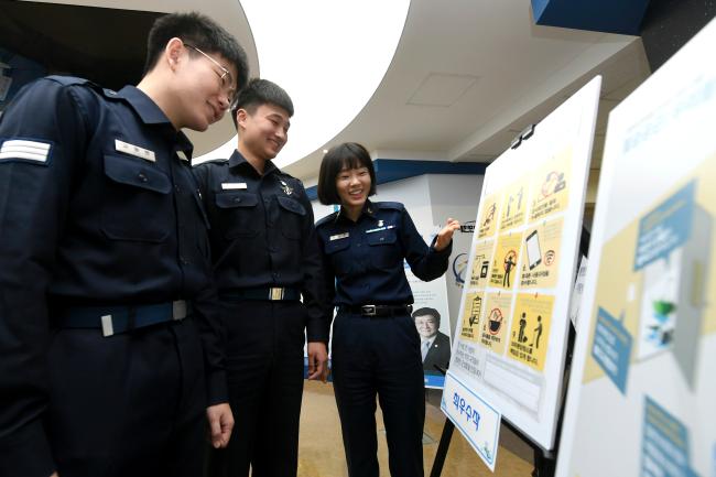 공군 장병들이 22일 ‘제1회 법문화·인권주간’의 세부행사로 진행된 ‘생활관 헌법 만들기 대회’ 수상 작품을 관람하고 있다.  공군 제공