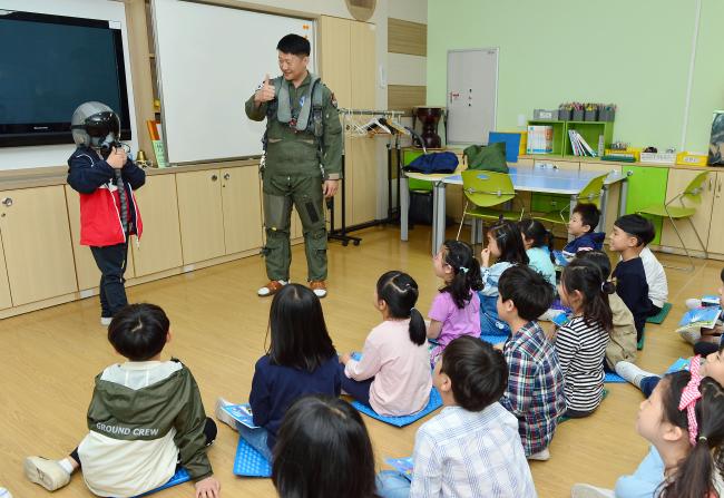 7일 오전 공군8전투비행단의 직업소개교육에서 이경주(소령) 조종사가 아이들에게 조종장구에 대해 설명하고 있다.  사진 제공=전미화 중사