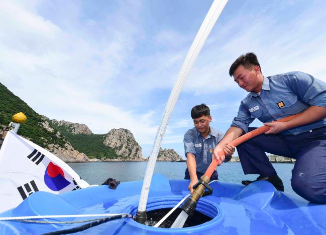 장병들이 신안군 홍도의 한 가정을 찾아 물개(LCU-85정)를 이용해 주민이 이용할 청수를 공급하고 있다.  