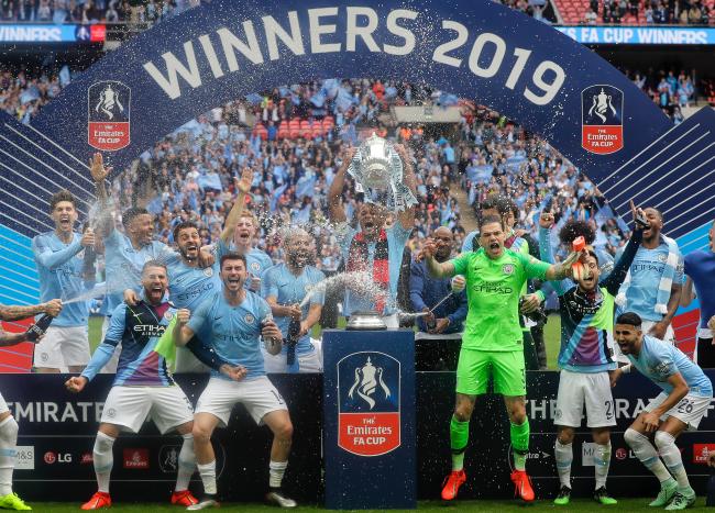 맨체스터 시티 선수들이 19일(한국시간) 영국 런던 웸블리 스타디움에서 열린 잉글랜드축구협회(FA)컵 결승에서 승리한 후 우승컵을 들고 환호하고 있다.  
 연합뉴스