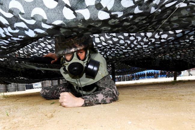 12일 해군헌병단이 진해기지사령부 헌병전대 연병장에서 개최한 ‘경계헌병 전투기량 경연대회’ 중 참가 장병이 포복으로 장애물을 극복하고 있다.  부대 제공 