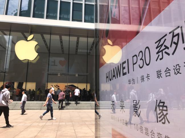 중국 상하이 난징둥루에 있는 애플 스토어 앞에 화웨이의 전략 스마트폰 P30 시리즈 광고물이 서 있다.  연합뉴스