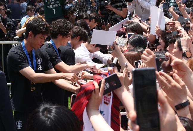 17일 U-20 축구대표팀 환영 행사가 열린 서울광장 믹스트존에서 선수들이 몰려든 팬들에게 사인을 해주고 있다.   연합뉴스