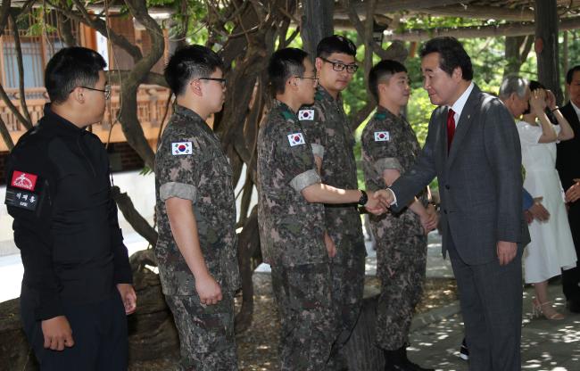 이낙연(맨 오른쪽) 국무총리가 17일 서울 종로구 총리공관에서 열린 유해발굴감식단 초청 오찬행사에서 오찬에 앞서 단원들과 악수하며  격려하고 있다.  연합뉴스 