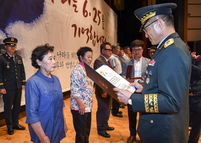 25일 제주 한라대학교 한라아트홀에서 열린 ‘제주지역 6·25전쟁 무공훈장 수여식’ 행사에서 육군인사사령부 손승호(오른쪽) 인사행정처장이 서훈 대상자 23명의 유가족에게 훈장을 대리 수여하고 있다.  육군 제공