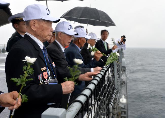 ‘대한해협해전 전승 69주년 기념 행사’에서 세종대왕함에 승함한 대한해협해전 참전용사들이 해상헌화를 하고 있다. 부대 제공