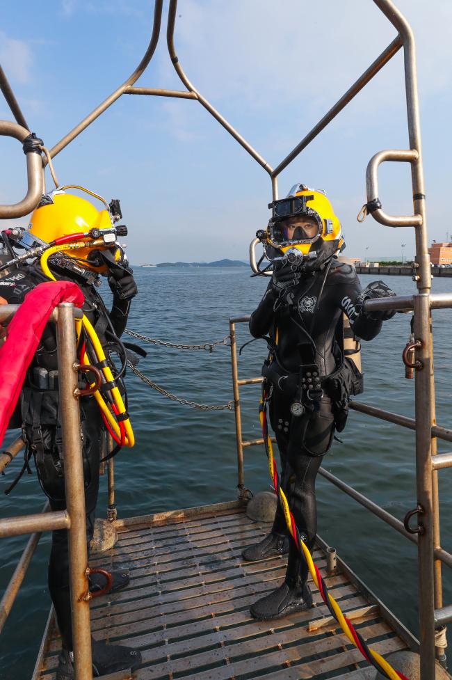 
해군 해난구조전대 심해잠수사 훈련 체험에 나선 이연화 국방홍보원 홍보위원이 표면공급잠수체계(SSDS) 장비를 착용하고 다이버 스테이지에 올라 대기하고 있다.  