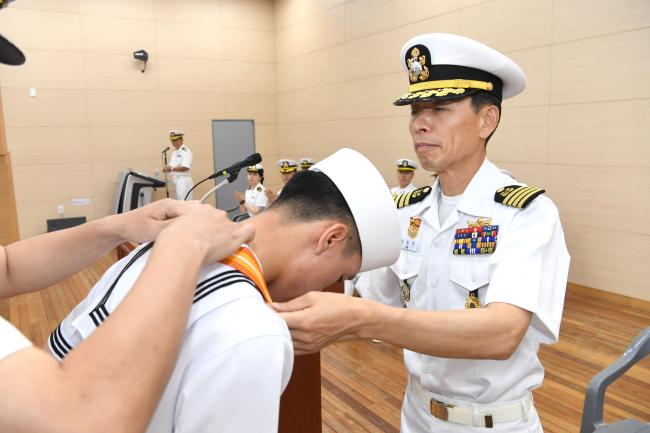 지난 19일 해군교육사령부 기초군사교육단 신병교육대대 교육관에서 거행된 제658기 해군병 정모 수여 및 수료식에서 이민구(오른쪽) 기초군사교육단장이 한 수병에게 메달을 걸어주고 있다.   사진 제공=박미현 중사(진)