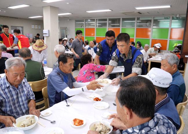 지난 19일 육군3기갑여단 태극대대 태극봉사단 간부들이 중복을 앞두고 무더위에 지친 지역 어르신들께 삼계탕 300그릇을 직접 만들어 대접하고 있다.  부대 제공