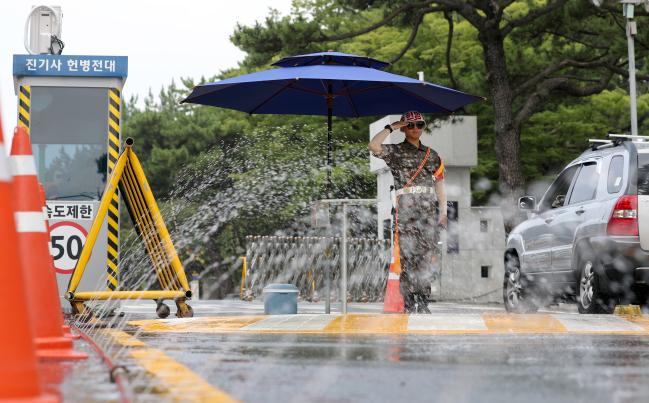 절기상 가장 덥다는 대서(大暑)인 23일 해군진해기지사령부(진기사) 헌병전대 장병이 진해기지 1정문에 설치된 대형 그늘막 아래서 출입 차량을 확인하고 있다. 진기사는 해군 모항(母港)의 관문을 수호하는 정문 헌병들에게 쾌적한 근무환경을 제공하기 위해 냉방기가 설치된 이동형 근무 부스를 제공하고, 지열을 낮추기 위해 스프링클러를 지속적으로 가동하고 있다. 또 아이스박스를 비치해 언제든지 시원한 음료와 얼음 팩을 사용할 수 있도록 해서 호평을 받고 있다.       진해=양동욱 기자