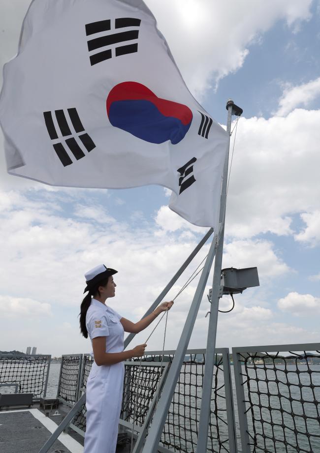 해군3함대 광주함 해상작전 훈련 체험에 나선 임미소 국방홍보원 홍보위원이 출항에 맞춰 광주함 함미 갑판에서 바람에 펄럭이는 태극기를 내리고 있다.
