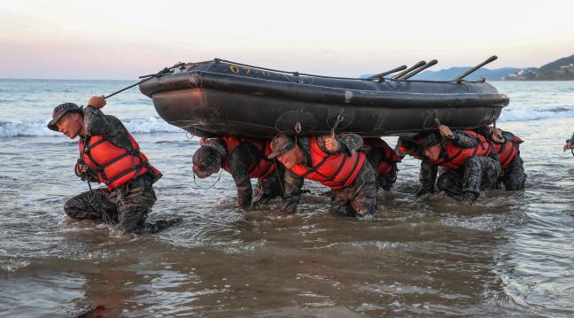 경북 포항 남구 도구해안에서 97차 수색전문교육생들이 고무보트(IBS)를 머리에 이고 오리걸음으로 전진하고 있다. 