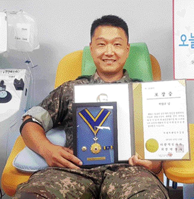 육군102기갑여단 불사조대대 박범규 중사가 헌혈 유공 명예장을 들고 기념사진을 찍고 있다.   부대제공
