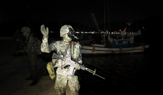 기동타격대 장병들이 야간투시경을 착용하고 가상의 적 수영침투조가 접안할 것으로 예상되는 부둣가 일대에서 수색작전을 펼치고 있다.
