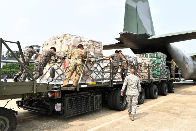 공군군수사령부 60수송전대가 19일 실시한 ‘한미 적하역 장비 상호지원 훈련’에서 한미 장병들이 함께 C-130 수송기에 공수화물을 적재하고 있다. 
 부대 제공