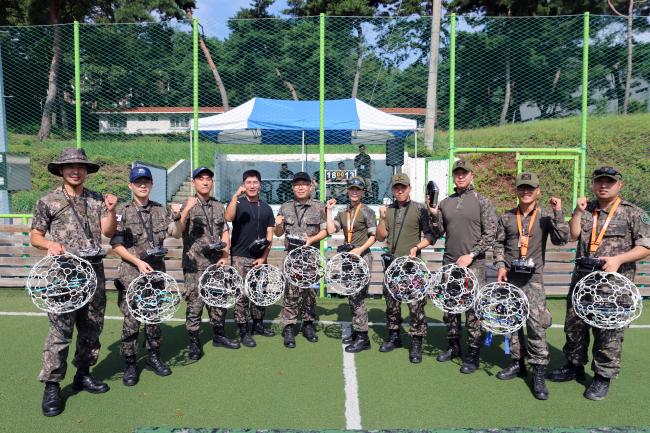 지난 10일 제3회 드론 고등기술 경연대회에 참가한 장병들이 경연대회에 사용할 드론을 들고 파이팅을 외치고 있다.  부대 제공