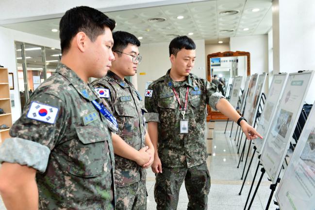 공군11전투비행단 장병들이 부대 안에서 열린 ‘교통안전 사진 전시회’에서 전시 내용을 살펴보고 있다.  부대 제공 