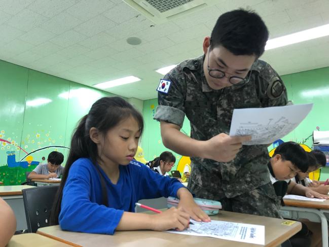육군8군단 흑곰포병대대 박창대(오른쪽) 병장이 고성 청소년 수련관에서 지역 학생들에게 영어를 가르쳐주고 있다. 부대 제공

