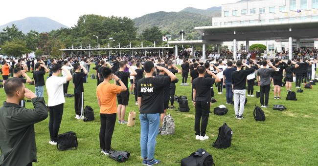 16일 해군교육사령부 연병장에서 열린 ‘제265기 해군 부사관 후보생 입영식’에서 입영 장정들이 가족들을 향해 경례하고 있다.   부대 제공