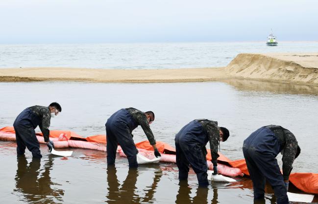 군·경 합동 누유 확산 방지 훈련에서 공군18전투비행단 장병들이 흡착포를 이용해 누출된 가상의 유류를 제거하고 있다.  사진 제공=한창현 하사