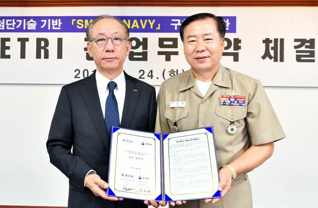 심승섭(오른쪽) 해군참모총장이 24일 해군본부 중회의실에서 열린 ‘해군-한국전자통신연구원 업무 협약식’에서 김명준 한국전자통신연구원장과 협약서를 들고 기념사진을 찍고 있다.   해군 제공