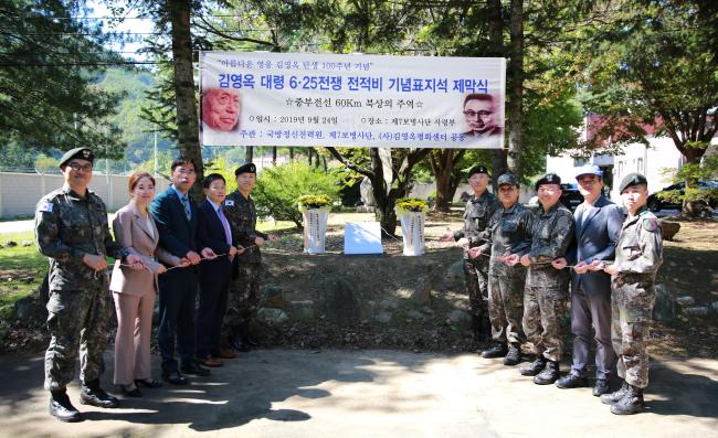 24일 열린 아름다운 영웅, 고(故) 김영옥 대령  6·25전쟁 전적비 기념표지석 제막식에서 나승용(준장·오른쪽 다섯째) 국방정신전력원장과 박원호(소장·왼쪽 다섯째) 육군7사단장, 이병렬(왼쪽 넷째) (사)김영옥평화센터 이사 등 행사 관계자들이 제막 행사를 하고 있다. 
 사진 제공=최광진 상병