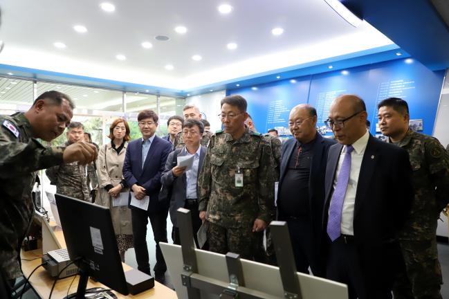 17일 육군5군지사에서 열린 ‘민·군 협력 정비기술개발 시연회’에서 장두영(준장·앞줄 오른쪽 셋째) 5군지사령관을 비롯한 참석자들이 기술개발과정에 대한 설명을 듣고 있다.  부대 제공 